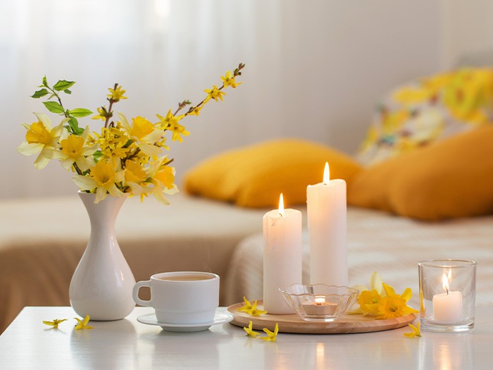 Coffee table topped with a vase of flowers and candles.